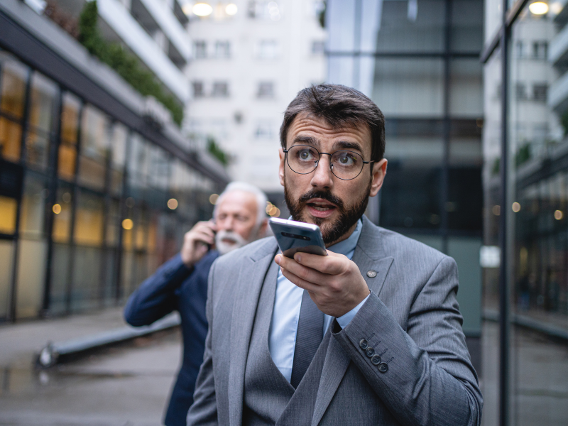 businessman sending a voice message while walking down the street